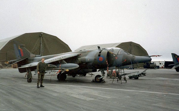 Falklandinseln, Flughafen Stanley 1984, Flug 1453, Harrier GR3 'L'. Im Hintergrund sollte 'T' bald während eines Flugplatzangriffs im Hafen abstürzen. Foto mit freundlicher Genehmigung von Pete Butt