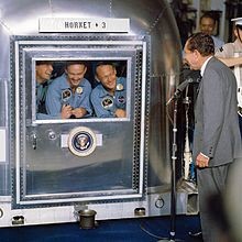 Apollo 11 crew, Neil A. Armstrong, Michael Collins, Edwin Aldrin, inside the Mobile Quarantine Facility being greeted by President Nixon aboard Hornet