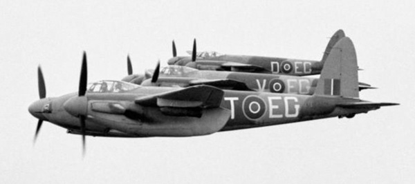 Three Mosquito FB Mark VIs of No. 487 Squadron RNZAF based at Hunsdon, Hertfordshire, flying in tight starboard echelon formation, with 500-lb MC bombs on underwing carriers