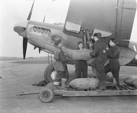 Armourers’ hand-winch a 500-lb MC bomb to the wing loading-point on Mosquito FB Mark VI, MM403 ‘SB-V’, of No. 464 Squadron RAAF at Hunsdon, Hertfordshire