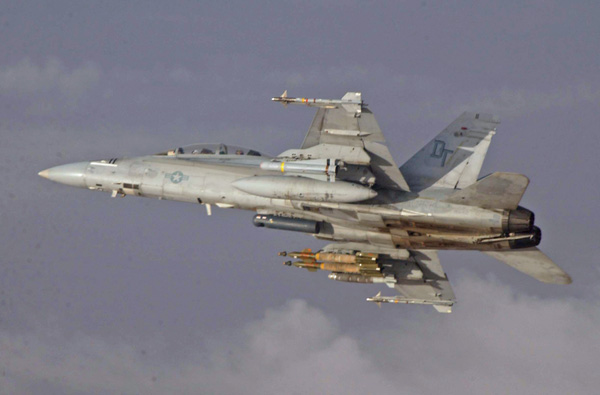 An F/A-18D Hornet with Marine All Weather Fighter Attack Squadron 242 banks away into the clouds after refueling from a KC-130 with Marine Aerial Refueler Transport Squadron 452 near Fallujah, Iraq, late in the day Nov. 9.  In support of Marines fighting on the ground in the streets of Fallujah during Operation Phantom Fury, the Hornet is one of the 3rd Marine Aircraft Wing's fixed-wing aircraft that employs Joint Direct Attack Munitions, such as two laser guided GBU-12s and a GBU-38 seen under the Hornet's right wing. Photo by Cpl. Paul Leicht