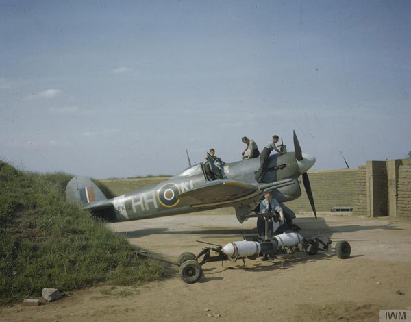 A Hawker Typhoon Mark IB (s/n EK139, "HH-N") "Dirty Dora", of No 175 Squadron, Royal Air Force, undergoing servicing in a blast-walled dispersal point at Colerne. Two dummy bombs for practice loading on to the wing racks can be seen in the foreground.