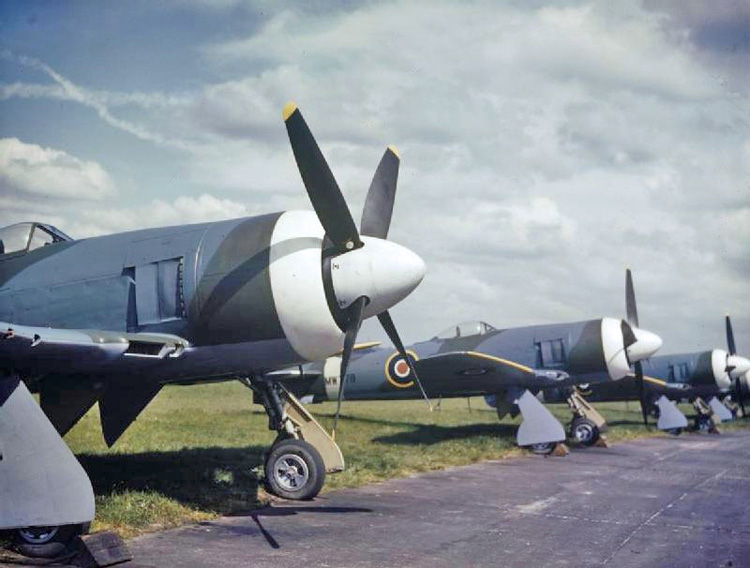 Pesawat Hawker Tempest Mark II Angkatan Udara Kerajaan berbaris di samping landasan di pabrik Hawker Aircraft Ltd di Langley, Berkshire (UK). Sumber Wikipedia